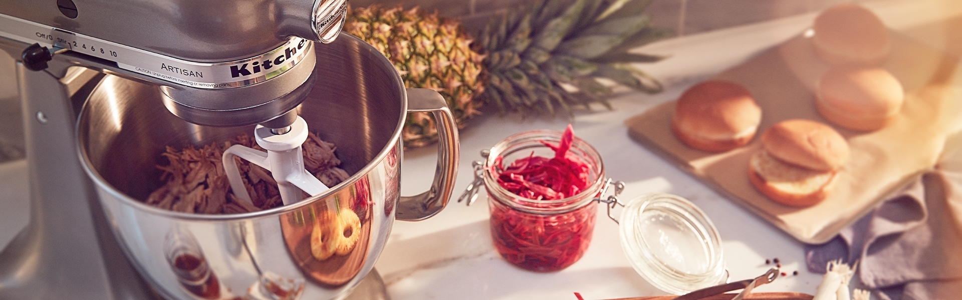 Stand mixer with bowl, pineapple, buns and salad
