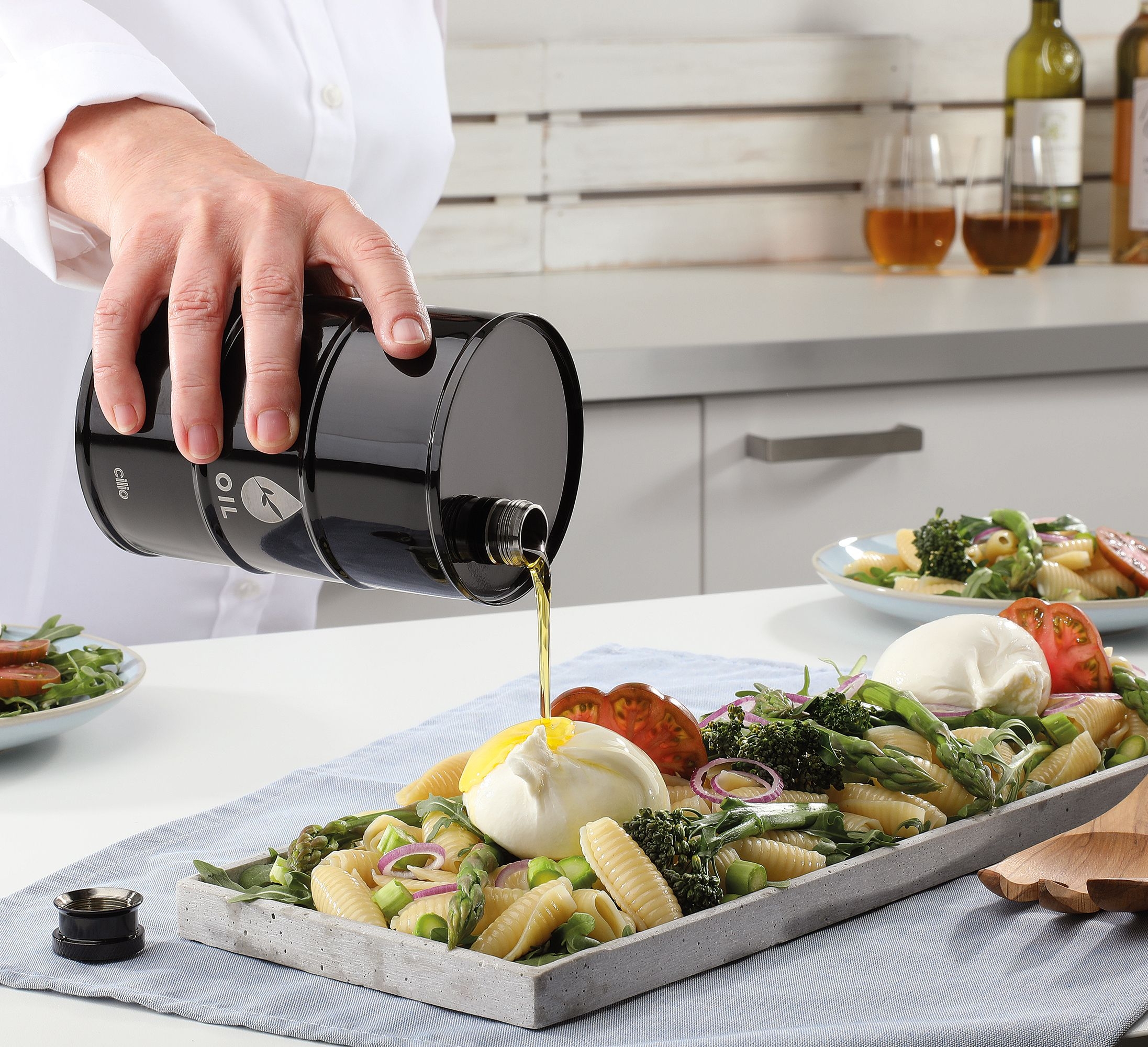 Black cilio BARILE oil drum pouring olive oil on pasta