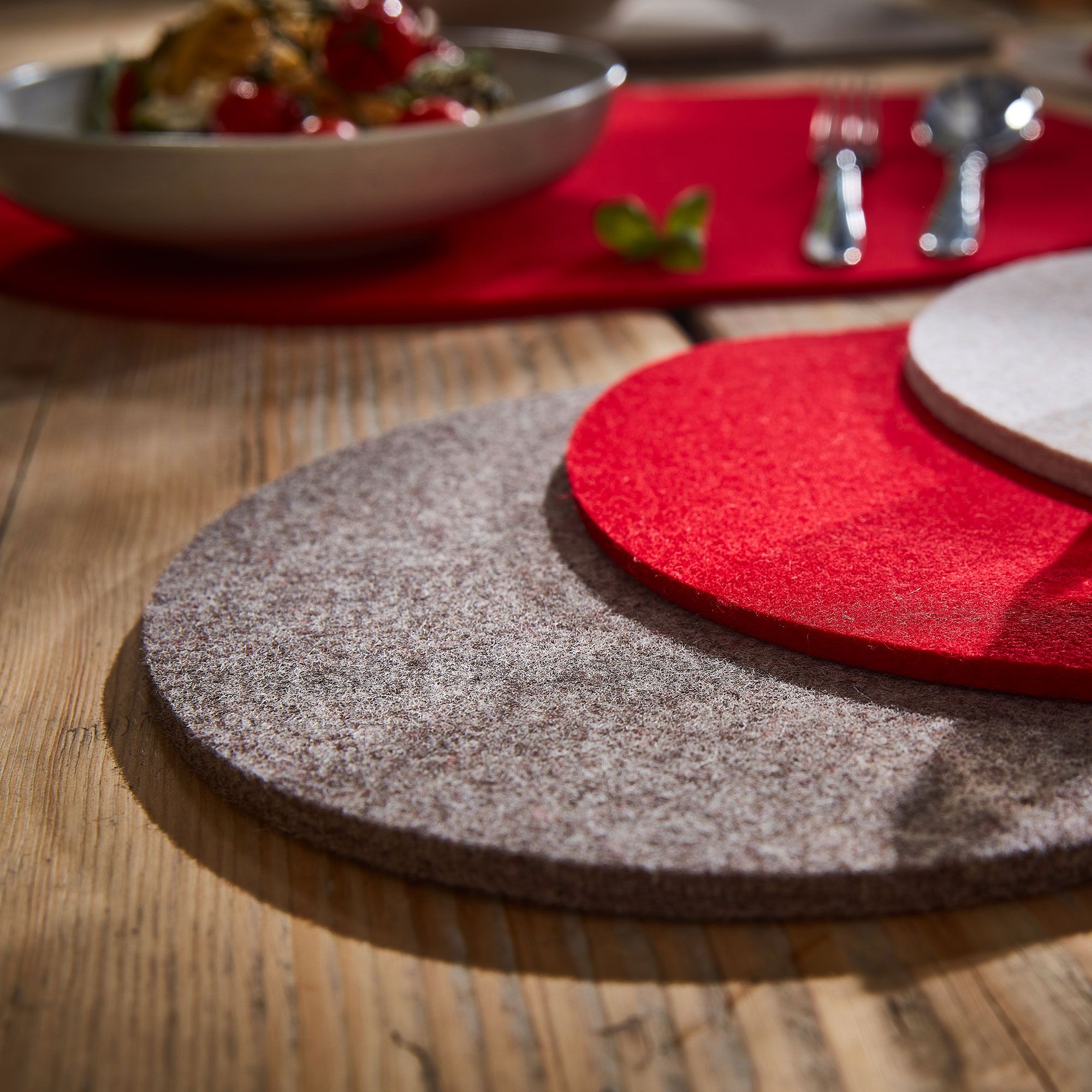 Runde Filzuntersetzer in Grau und Rot auf Holztisch