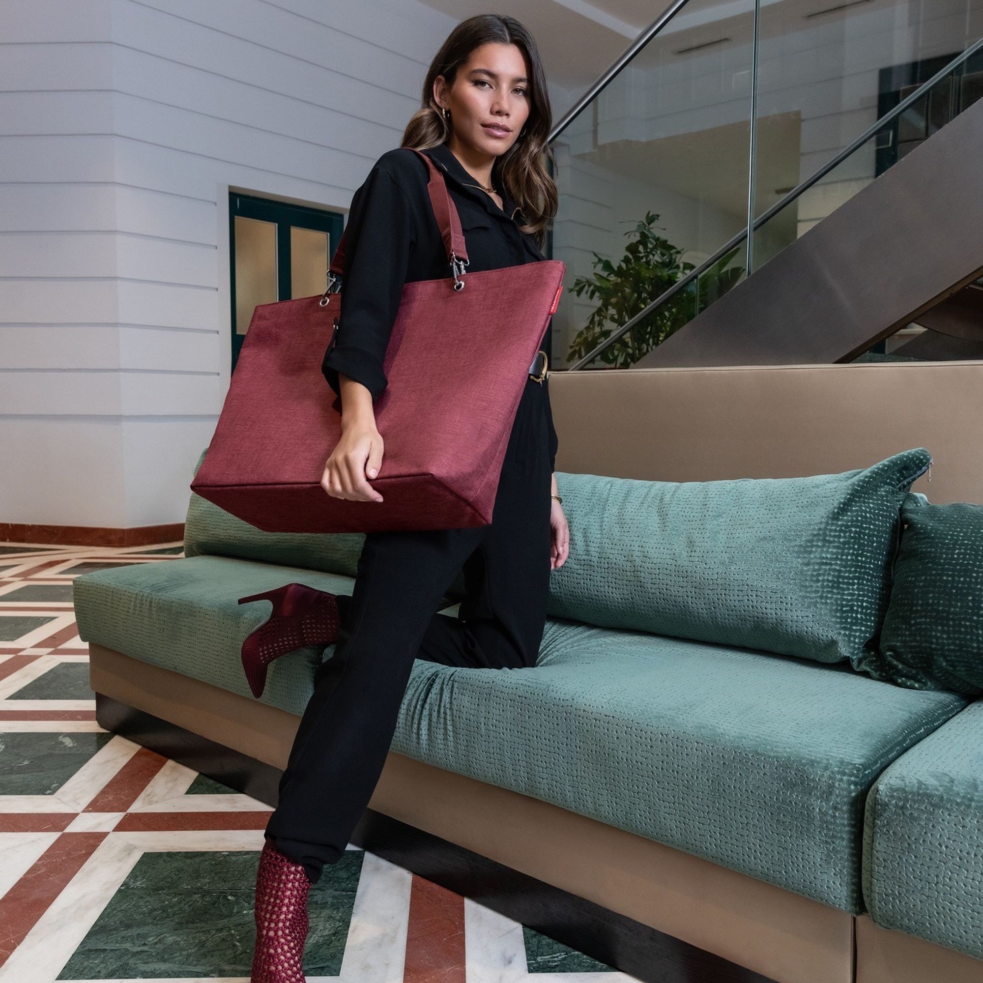 Woman with large burgundy shoulder bag in hotel