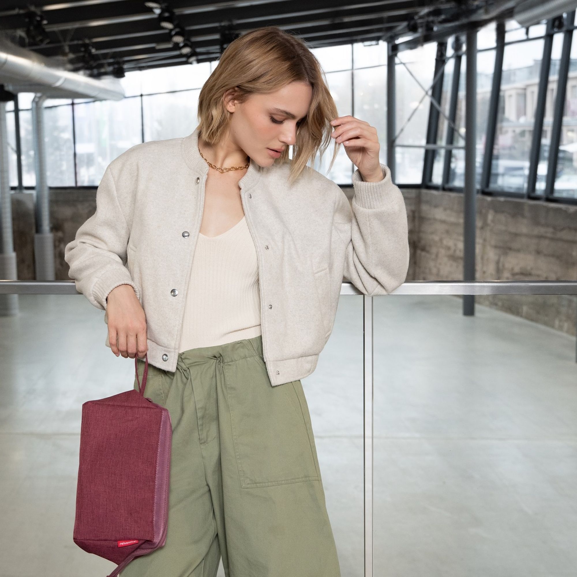 Woman in beige bomber jacket and green trousers