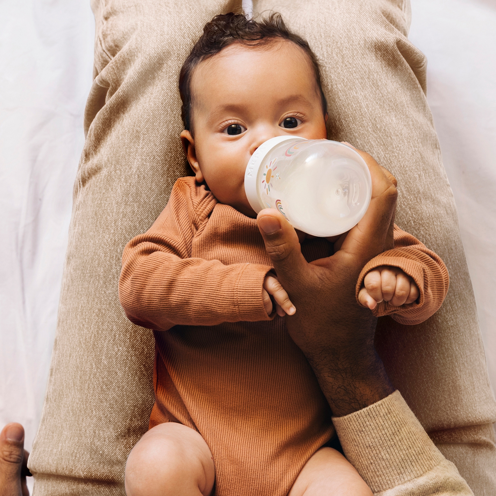 Baby drinking from Mepal Mio sunshine & rainbow bottle
